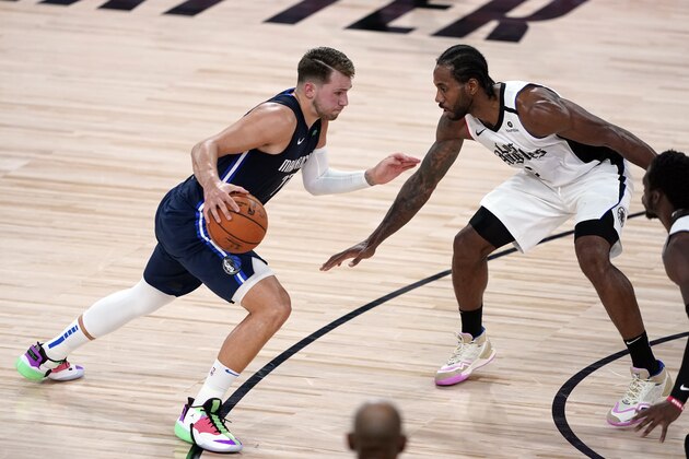 Dallas Mavericks' Luka Doncic, left, drives toward the basket as Los Angeles Clippers' Kawhi Leonard defends during the second half of an NBA basketball first round playoff game Sunday, Aug. 23, 2020, in Lake Buena Vista, Fla. (AP Photo/Ashley Landis, Pool)