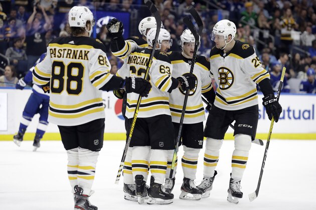 Boston Bruins left wing Brad Marchand (63) celebrates his goal against the Tampa Bay Lightning with right wing David Pastrnak (88) and defenseman Brandon Carlo (25) during the first period of an NHL hockey game Tuesday, March 3, 2020, in Tampa, Fla. (AP Photo/Chris O'Meara)