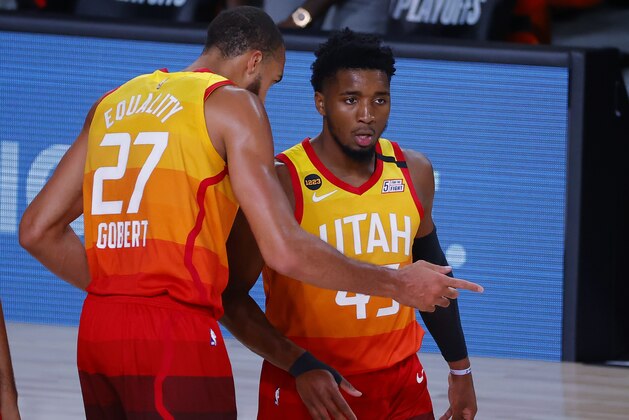 Utah Jazz's Donovan Mitchell, right, talks with Rudy Gobert during the first quarter against the Denver Nuggets in Game 4 of an NBA basketball first-round playoff series, Sunday, Aug. 23, 2020, in Lake Buena Vista, Fla. (Kevin C. Cox/Pool Photo via AP)