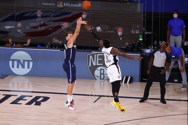 Dallas Mavericks' Luka Doncic, left, hits a winning three-point basket against Los Angeles Clippers' Reggie Jackson (1) during overtime of Game 4 of an NBA basketball first-round playoff series, Sunday, Aug. 23, 2020, in Lake Buena Vista, Fla. (Kevin C. Cox/Pool Photo via AP)