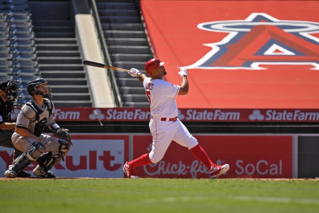 Los Angeles Angels' Albert Pujols, right, hits a grand slam as Houston Astros catcher Dustin Garneau, second from left, and home plate umpire Alfonso Marquez watch during the third inning of a baseball game Sunday, Aug. 2, 2020, in Anaheim, Calif. (AP Photo/Mark J. Terrill)