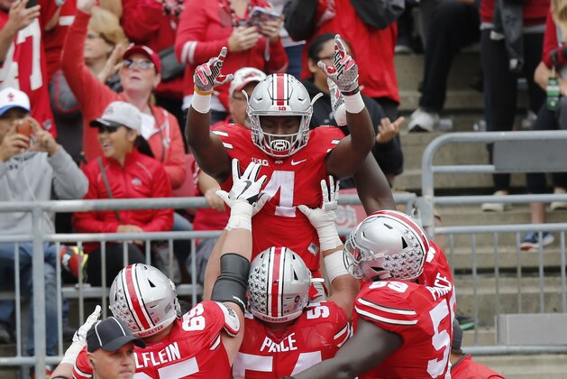 FILE - In this Oct. 1, 2016, file photo, Ohio State running back Curtis Samuel, top, celebrates his touchdown against Rutgers during the first half of an NCAA college football game in Columbus, Ohio. With the help of a loving family that kept his priorities straight and a well-connected high school coach, Samuel went from hearing the rumble of the elevated subway train next to Sid Luckman Field to the roar of 100,000 Ohio State fans at the Horseshoe. (AP Photo/Jay LaPrete, File)