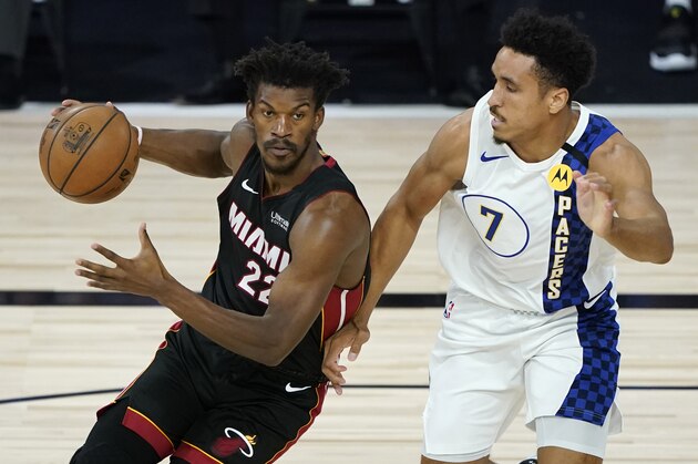 Miami Heat's Jimmy Butler (22) drives into Indiana Pacers' Malcolm Brogdon (7) during the first half of an NBA basketball first round playoff game Monday, Aug. 24, 2020, in Lake Buena Vista, Fla. (AP Photo/Ashley Landis, Pool)