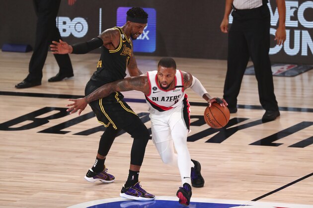Portland Trail Blazers guard Damian Lillard (0) drives to the basket against Los Angeles Lakers guard Kentavious Caldwell-Pope (1) in the first half of Game 4 of an NBA basketball first-round playoff series, Monday, Aug. 24, 2020, in Lake Buena Vista, Fla. (Kim Klement/Pool Photo via AP)