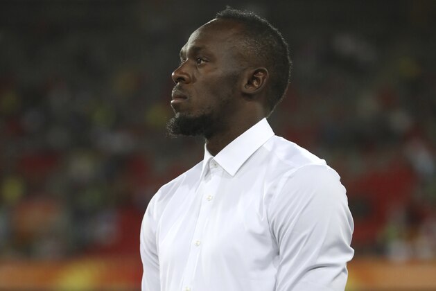 Former Olympic and world sprint champ[ion Usain Bolt stands on the track after presenting medals to the women's 200m winners at Carrara Stadium during the 2018 Commonwealth Games on the Gold Coast, Australia, Thursday, April 12, 2018. (AP Photo/Mark Schiefelbein)