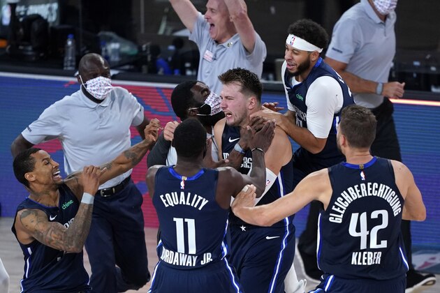 Dallas Mavericks' Luka Doncic, center, celebrates with teammates after making a game-winning 3-point basket against the Los Angeles Clippers during overtime of an NBA basketball first round playoff game Sunday, Aug. 23, 2020, in Lake Buena Vista, Fla. The Mavericks won 135-133 in overtime. (AP Photo/Ashley Landis, Pool)