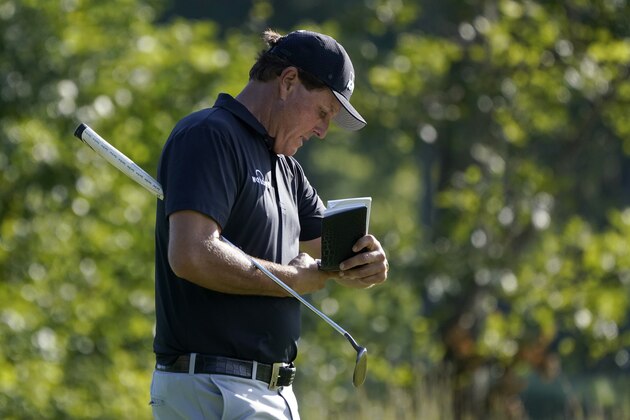 Phil Mickelson refers to his notes as he walks up onto the 14th green during the second round of the Northern Trust golf tournament at TPC Boston, Friday, Aug. 21, 2020, in Norton, Mass. (AP Photo/Charles Krupa)