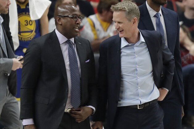 Golden State Warriors coach Steve Kerr, right, walks with assistant coach Mike Brown after Game 3 of the team's NBA basketball playoffs Western Conference finals against the Portland Trail Blazers, Saturday, May 18, 2019, in Portland, Ore. The Warriors won 110-99. (AP Photo/Ted S. Warren)