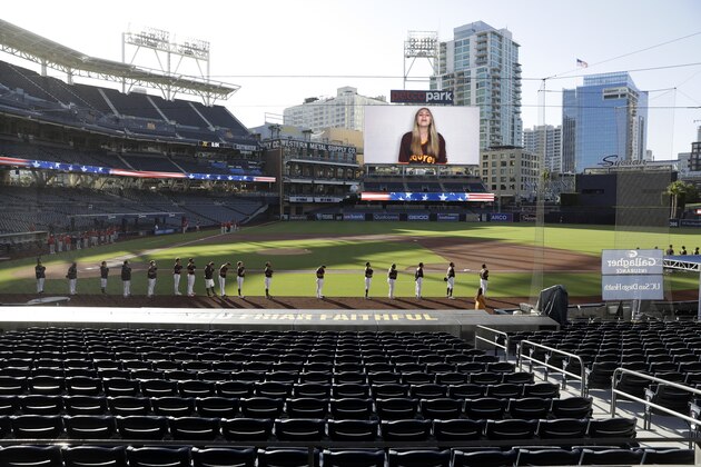 The San Diego Padres, front, and the Los Angeles Angels stand for the singing of the national anthem before an exhibition baseball game at Petco Park, Monday, July 20, 2020, in San Diego. (AP Photo/Gregory Bull)