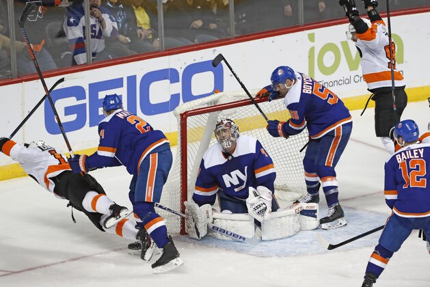New York Islanders defenseman Scott Mayfield (24) sends Philadelphia Flyers center Sean Couturier (14) flying, left, as Islanders goaltender Semyon Varlamov (40) reacts after allowing a game-tying goal to the Flyers during the third period of an NHL hockey game, Tuesday, Feb. 11, 2020, in New York. The Islanders defeated the Flyers 5-3. Islanders defenseman Johnny Boychuk (55) looks in the crease as Flyers right wing Jakub Voracek (93) reacts. (AP Photo/Kathy Willens)