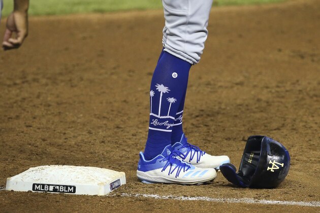 Los Angeles Dodgers' KikÃ© Hernandez stands at first base after a pop fly out against the Arizona Diamondbacks as the MLB and BLM for