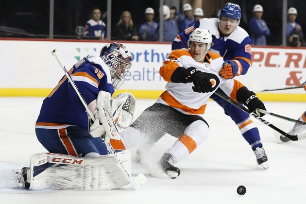 FILE - In This Feb. 11, 2020, file photo, New York Islanders goaltender Semyon Varlamov (40) deflects the puck as Islanders left wing Kieffer Bellows (20) keeps Philadelphia Flyers right wing Nicolas Aube-Kubel (62) away during the first period of an NHL hockey game in New York. The NHL ditched divisional playoffs to go back to the old-school format for its summer postseason and still ended up with all division rivals facing off in the second round. Itâ€™s the Flyers against Islanders in the Metropolitan series. (AP Photo/Kathy Willens, File)