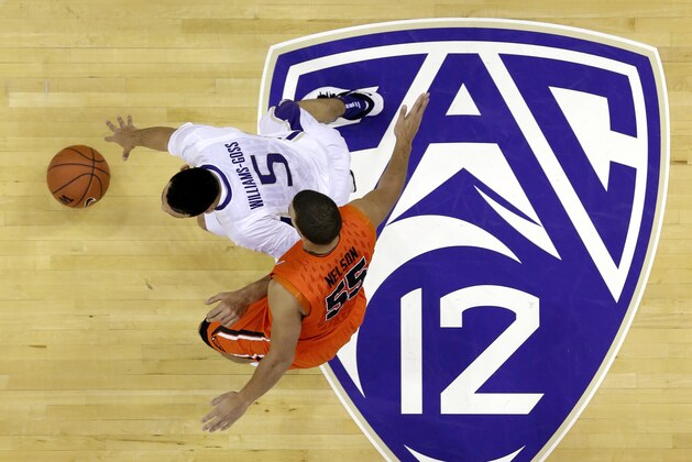 FILE - In this Jan. 25, 2014, file photo, Washington's Nigel Williams-Goss (5) dribbles past Oregon State's Roberto Nelson and across a Pac-12 logo in the first half of an NCAA college basketball game in Seattle. The Pac-12 has proposed changing NCAA rules to allow college athletes to use their names, images and likenesses for their non-athletic business ventures.  The Pac-12's proposal will be taken up by the five autonomous conferences (Big Ten, Big 12, Atlantic Coast Conference and Southeastern Conference) and could be voted on at the NCAA convention in January. (AP Photo/Elaine Thompson, File)