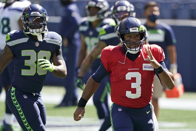 Seattle Seahawks quarterback Russell Wilson (3) takes part in warmups near running back Carlos Hyde, left, before an NFL football mock game, Wednesday, Aug. 26, 2020, in Seattle. (AP Photo/Ted S. Warren)