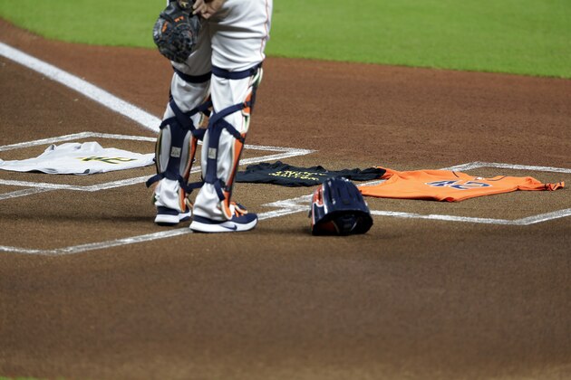 Houston Astros catcher Martin Maldonado stands next to a T-shirt of Black Live Matter and team jerseys with No, 42, in honor of Jackie Robinson Day, before both teams walked off the field to protest racial injustice before their baseball game Friday, Aug. 28, 2020, in Houston. (AP Photo/Michael Wyke)