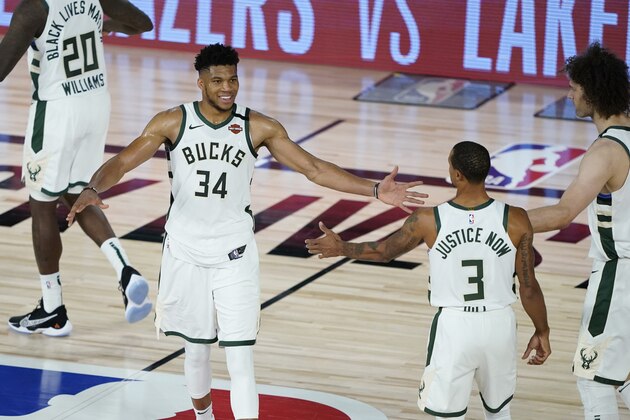 Milwaukee Bucks forward Giannis Antetokounmpo (34) celebrates the team's win over the Orlando Magic with guard George Hill (3) and center Robin Lopez (42) in an NBA basketball first round playoff game, Thursday, Aug. 20, 2020, in Lake Buena Vista, Fla. (AP Photo/Ashley Landis, Pool)