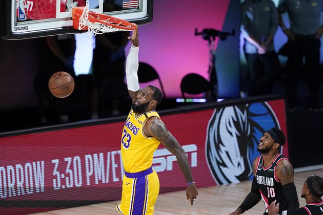 Los Angeles Lakers' LeBron James (23) scores ahead of Portland Trail Blazers' Carmelo Anthony (00) during the first half of an NBA basketball first round playoff game Saturday, Aug. 29, 2020, in Lake Buena Vista, Fla. (AP Photo/Ashley Landis)