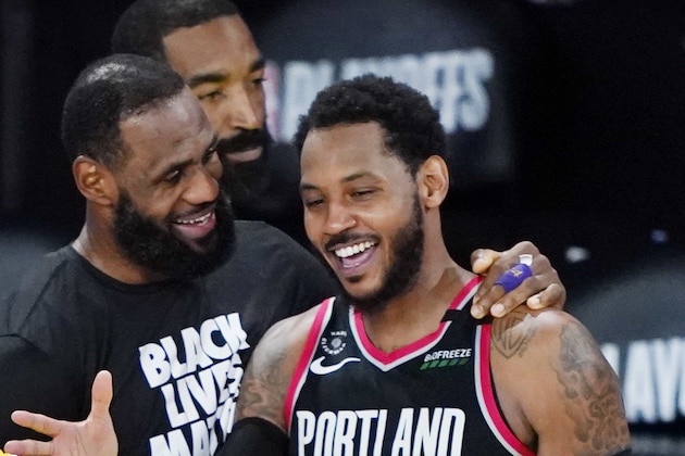 Los Angeles Lakers' Kyle Kuzma (0) and LeBron James, center, greet Portland Trail Blazers' Carmelo Anthony (00) after an NBA basketball first round playoff game Saturday, Aug. 29, 2020, in Lake Buena Vista, Fla. The Lakers won 131-122 to win the series 4-1. (AP Photo/Ashley Landis)
