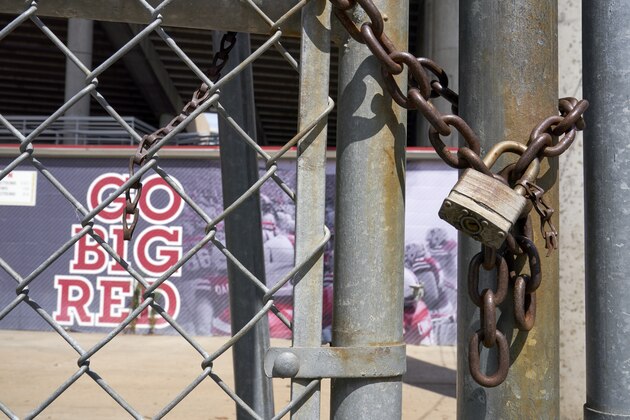 Gates leading into Memorial Stadium are padlocked, in Lincoln, Neb., Wednesday, Aug. 12, 2020. The Big Ten won't play football this fall because of concerns about COVID-19, becoming the first of college sports' power conferences to yield to the pandemic. The move announced Tuesday. (AP Photo/Nati Harnik)