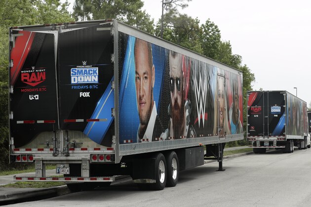 Equipment trailers are lined up at the entrance road to the WWE Performance Center Tuesday, April 14, 2020, in Orlando, Fla.  Florida’s top emergency official last week amended Gov. Ron DeSantis’ stay-at-home order to include employees at the professional sports and media production with a national audience, if the location is closed to the public. (AP Photo/John Raoux)