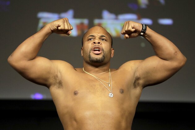 Daniel Cormier reacts while posing atop a scale prior to his heavyweight mixed martial arts bout against Derrick Lewis during the weigh-ins ahead of UFC 230, Friday, Nov. 2, 2018, at Madison Square Garden in New York. (AP Photo/Julio Cortez)