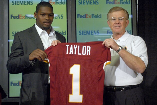 ** FILE ** Washington Redskins first-round draft pick Sean Taylor of Miami, left, holds up a Redskins jersey with coach Joe Gibbs during a news conference in Ashburn, Va., in this April 26, 2004 file photo. Taylor died early Tuesday Nov. 27, 2007 at Jackson Memorial Hospital in Miami, a day after he was shot at home in Palmetto Bay, Fla.,  by what police say was an intruder. He was 24. (AP Photo/Kevin Wolf)