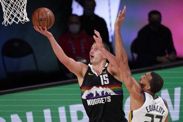 Denver Nuggets' Nikola Jokic (15) goes up for a shot as Utah Jazz's Rudy Gobert (27) defends during the second half an NBA first round playoff basketball game, Tuesday, Sept. 1,2020, in Lake Buena Vista, Fla. (AP Photo/Mark J. Terrill)