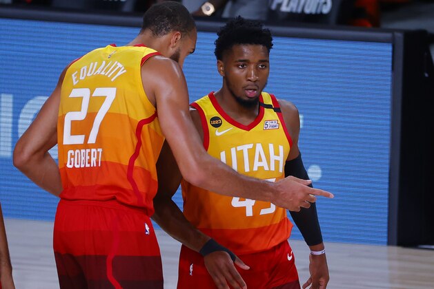 Utah Jazz's Donovan Mitchell, right, talks with Rudy Gobert during the first quarter against the Denver Nuggets in Game 4 of an NBA basketball first-round playoff series, Sunday, Aug. 23, 2020, in Lake Buena Vista, Fla. (Kevin C. Cox/Pool Photo via AP)