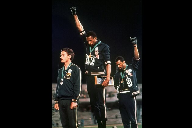 FILE - In this Oct. 16, 1968 file photo, U.S. athletes Tommie Smith, center, and John Carlos raise their gloved fists after Smith received the gold and Carlos the bronze for the 200 meter run at the Summer Olympic Games in Mexico City. Some athletes are criticizing the International Olympic Committee for prohibiting political protests on the medal podium. Olympic officials reminded athletes last week not to make political statements at the Tokyo Olympics. (AP Photo/File)
