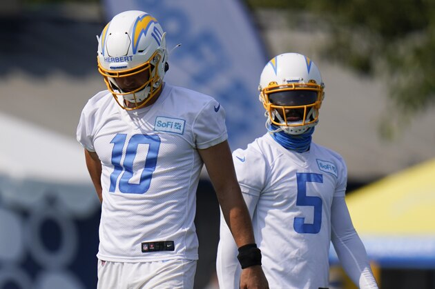 Los Angeles Chargers quarterbacks Justin Herbert, left, and Tyrod Taylor stand on the field during an NFL football camp practice Wednesday, Aug. 19, 2020, in Costa Mesa, Calif. (AP Photo/Jae C. Hong)