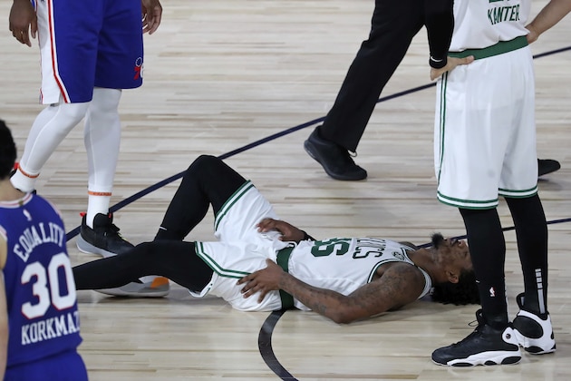Boston Celtics guard Marcus Smart (36) lies on the court after an apparent injury during the first half of Game 3 of an NBA basketball first-round playoff series against the Philadelphia 76ers, Friday, Aug. 21, 2020, in Lake Buena Vista, Fla. (Kim Klement/Pool Photo via AP)