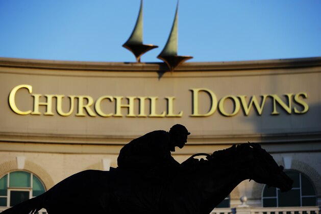 FILE - In this May 6, 2020 file photo a statue of Barbaro is silhouetted at the entrance of Churchill Downs in Louisville, Ky. Horse racing is in a state of transition at a time usually reserved for Triple Crown season. The Preakness would have been run Saturday, May 16, 2020 in Baltimore. But Pimlico Race Course and many tracks across North America remain dark because of the coronavirus pandemic. There is some light at the end of the tunnel as tracks including Churchill Downs in Kentucky are getting back to live racing without fans. (AP Photo/Darron Cummings, file) FILE - In this May 6, 2020 file photo a statue of Barbaro is silhouetted at the entrance of Churchill Downs in Louisville, Ky. Horse racing is in a state of transition at a time usually reserved for Triple Crown season. The Preakness would have been run Saturday, May 16, 2020 in Baltimore. But Pimlico Race Course and many tracks across North America remain dark because of the coronavirus pandemic. There is some light at the end of the tunnel as tracks including Churchill Downs in Kentucky are getting back to live racing without fans. (AP Photo/Darron Cummings, file)