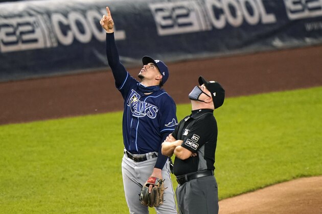 Tampa Bay Rays shortstop Willy Adames points up as he stands next to third base umpire Roberto Ortiz during the first inning of the team's baseball game against the New York Yankees, Wednesday, Sept. 2, 2020, at Yankee Stadium in New York. (AP Photo/Kathy Willens)