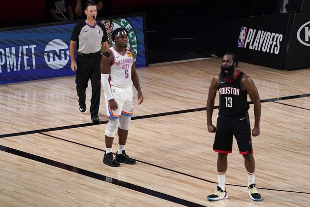 Referee Pat Fraher, left, and Oklahoma City Thunder's Luguentz Dort (5) look on as Houston Rockets' James Harden (13) celebrates after blocking a 3-point shot attempt by Dort during the second half of an NBA first-round playoff basketball game in Lake Buena Vista, Fla., Wednesday, Sept. 2, 2020. (AP Photo/Mark J. Terrill)