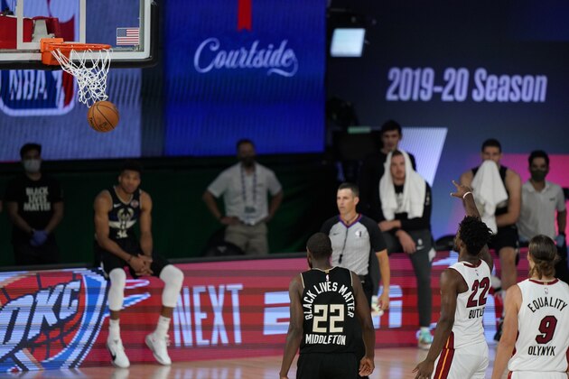 Miami Heat's Jimmy Butler (22) makes a free throw during the second half of an NBA conference semifinal playoff basketball game against the Milwaukee Bucks, Wednesday, Sept. 2, 2020, to give the Heat a 116-114 win over the Milwaukee Bucks in Lake Buena Vista, Fla. (AP Photo/Mark J. Terrill)