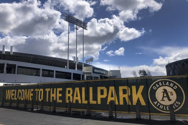 FILE - This March 25, 2020, file photo shows a banner to welcome to fans at the Oakland-Alameda County Coliseum in Oakland, Calif. The Athletics are placing their scouts and a significant number of other front office employees on furlough, suspending pay for minor leaguers and cutting the salaries of other executives as part of a cost-cutting move in response to the COVID-19 pandemic. A's owner John Fisher announced the moves Tuesday, May 26, 2020, in a rare public statement on what he called a