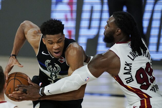 Miami Heat's Jae Crowder (99) knocks the ball loose from Milwaukee Bucks' Giannis Antetokounmpo (34), left, during the second half of an NBA conference semifinal playoff basketball game Wednesday, Sept. 2, 2020, in Lake Buena Vista, Fla. (AP Photo/Mark J. Terrill)