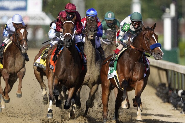 Florent Geroux rides Shedaresthedevil, second left, and John Velazquez rides Gamine, right, going into the first turn during the 146th running of the Kentucky Oaks at Churchill Downs, Friday, Sept. 4, 2020, in Louisville, Ky. (AP Photo/Mark Humphrey)