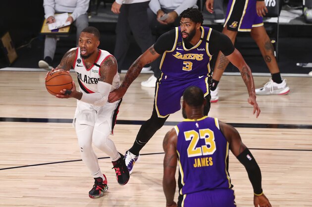 Portland Trail Blazers guard Damian Lillard (0) controls the ball against Los Angeles Lakers forward Anthony Davis (3) in the second half of Game 3 of an NBA basketball first-round playoff series, Saturday, Aug. 22, 2020, in Lake Buena Vista, Fla. (Kim Klement/Pool Photo via AP)