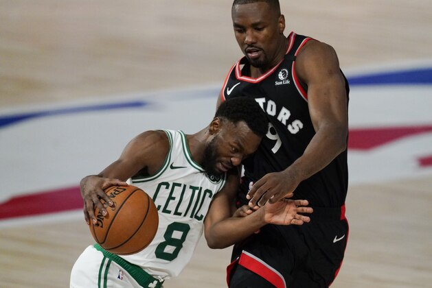 Boston Celtics' Kemba Walker (8) drives up court past Toronto Raptors' Serge Ibaka (9) during the second half of an NBA conference semifinal playoff basketball game Saturday, Sept. 5, 2020, in Lake Buena Vista, Fla. (AP Photo/Mark J. Terrill)