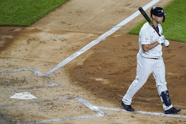 New York Yankees' Gary Sanchez carries his bat as he is walked by New York Mets starting pitcher David Peterson with the bases loaded dirng the third inning of the second baseball game of a doubleheader, Friday, Aug. 28, 2020, in New York. (AP Photo/John Minchillo)