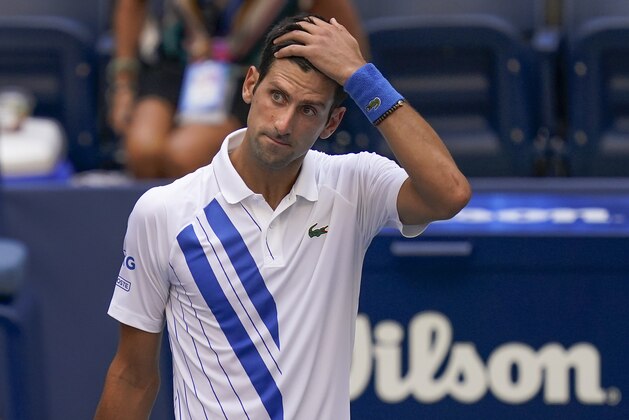 Novak Djokovic, of Serbia, reacts after inadvertently hitting a line judge with a ball after hitting it in reaction to losing a point against Pablo Carreno Busta, of Spain, during the fourth round of the US Open tennis championships, Sunday, Sept. 6, 2020, in New York. Djokovic defaulted the match. (AP Photo/Seth Wenig)