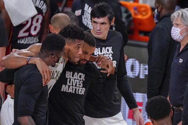 Milwaukee Bucks' Giannis Antetokounmpo is helped off the court after hurting his ankle during the first half of an NBA conference semifinal playoff basketball game against the Miami Heat Sunday, Sept. 6, 2020, in Lake Buena Vista, Fla. (AP Photo/Mark J. Terrill)
