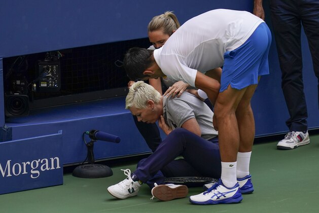 Novak Djokovic, of Serbia, checks a linesman after hitting her with a ball in reaction to losing a point to Pablo Carreno Busta, of Spain, during the fourth round of the US Open tennis championships, Sunday, Sept. 6, 2020, in New York. Djokovic defaulted the match. (AP Photo/Seth Wenig)