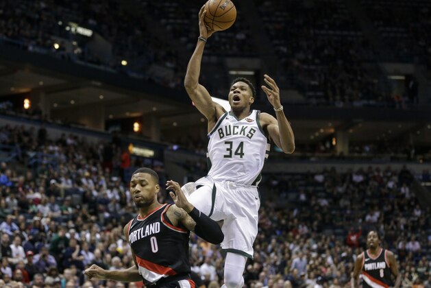 Milwaukee Bucks' Giannis Antetokounmpo (34) shoots over Portland Trail Blazers' Damian Lillard during the first half of an NBA basketball game Saturday, Oct. 21, 2017, in Milwaukee. (AP Photo/Tom Lynn)