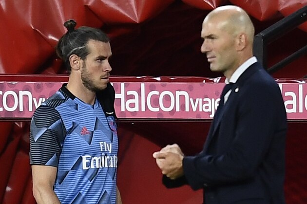 Real Madrid's head coach Zinedine Zidane, right, talks with Real Madrid's Gareth Bale during the Spanish La Liga soccer match between Granada and Real Madrid at the Los Carmenes stadium in Granada, Spain, Monday, July 13, 2020. (AP Photo/Jose Breton)