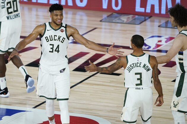 Milwaukee Bucks forward Giannis Antetokounmpo (34) celebrates the team's win over the Orlando Magic with guard George Hill (3) and center Robin Lopez (42) in an NBA basketball first round playoff game, Thursday, Aug. 20, 2020, in Lake Buena Vista, Fla. (AP Photo/Ashley Landis, Pool)