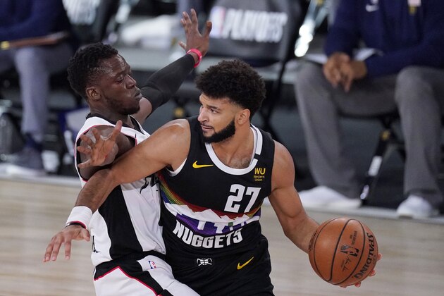 Los Angeles Clippers' Reggie Jackson, left, defends as Denver Nuggets' Jamal Murray (27) looks for help during the first half of an NBA conference semifinal playoff basketball game Monday, Sept. 7, 2020, in Lake Buena Vista, Fla. (AP Photo/Mark J. Terrill)