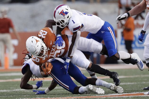 Texas running back Keaontay Ingram (26) is hit by Louisiana Tech safety L'Jarius Sneed (1) on a run during the first half of an NCAA college football game, Saturday, Aug. 31, 2019, in Austin, Texas. (AP Photo/Eric Gay)