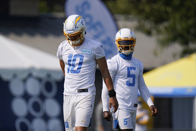 Los Angeles Chargers quarterbacks Justin Herbert, left, and Tyrod Taylor stand on the field during an NFL football camp practice Wednesday, Aug. 19, 2020, in Costa Mesa, Calif. (AP Photo/Jae C. Hong)